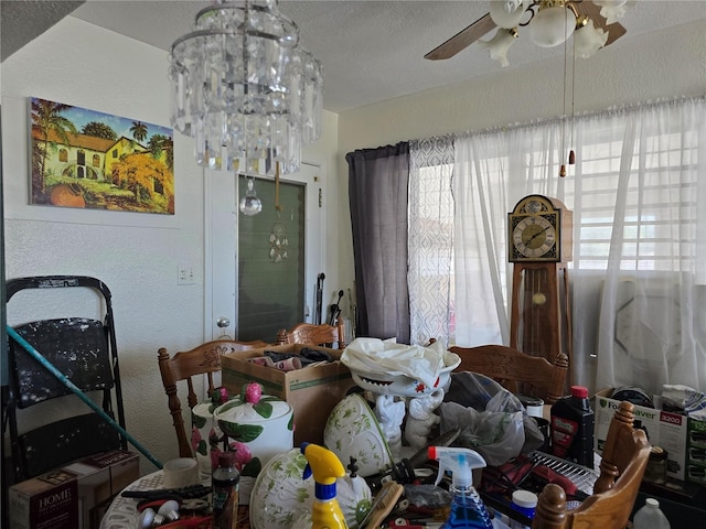 dining area featuring ceiling fan with notable chandelier