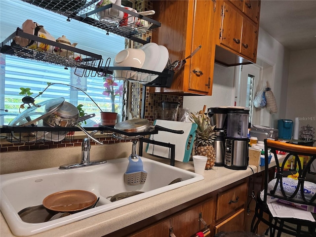 kitchen with light countertops, a sink, and brown cabinets