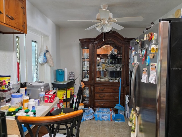 dining space with ceiling fan and tile patterned floors