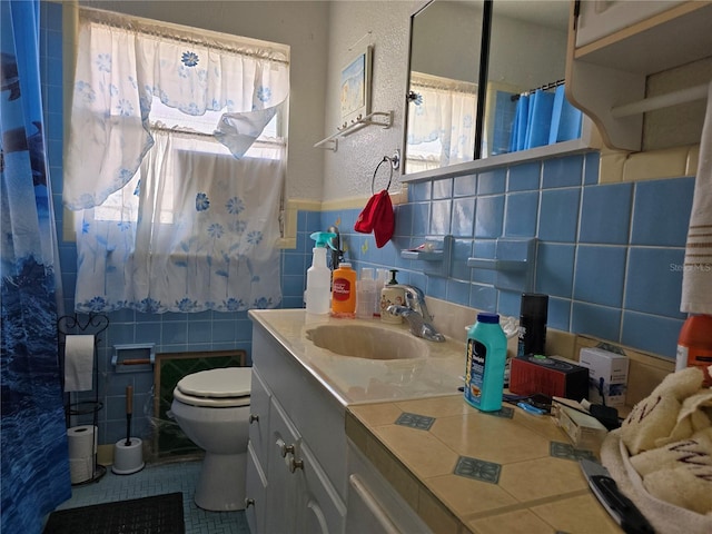 bathroom with tile walls, a shower with curtain, toilet, vanity, and tile patterned flooring