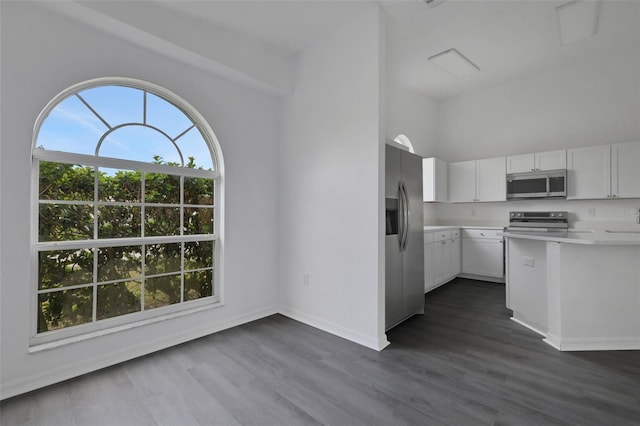 kitchen with light countertops, appliances with stainless steel finishes, dark wood finished floors, and white cabinetry