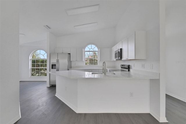 kitchen featuring stainless steel appliances, a sink, visible vents, light countertops, and a wealth of natural light