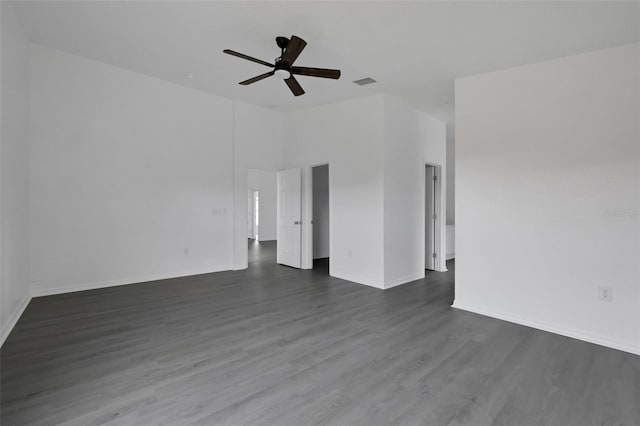 interior space featuring baseboards, visible vents, dark wood finished floors, a ceiling fan, and high vaulted ceiling