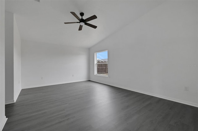 empty room with vaulted ceiling, dark wood-type flooring, a ceiling fan, and baseboards