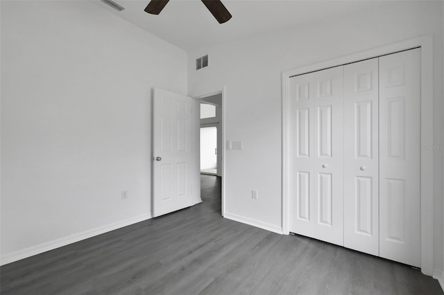 unfurnished bedroom featuring baseboards, a closet, visible vents, and dark wood-style flooring