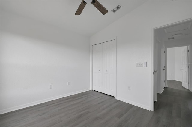 unfurnished bedroom featuring ceiling fan, dark wood-style flooring, visible vents, baseboards, and a closet