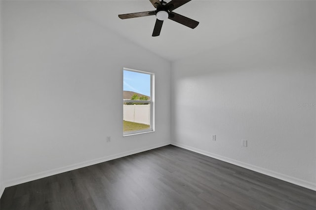 empty room featuring ceiling fan, baseboards, vaulted ceiling, and dark wood-style flooring