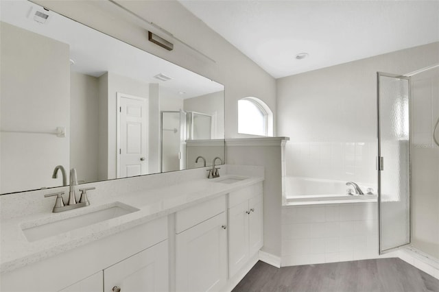 full bath with double vanity, a stall shower, a sink, and a bath