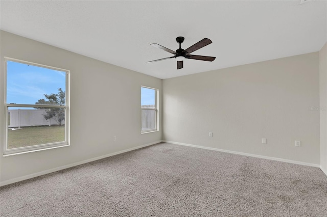 empty room featuring carpet floors, baseboards, and a ceiling fan