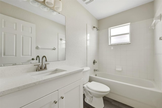 full bathroom with visible vents, a textured wall, toilet, vanity, and shower / tub combination