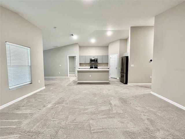 unfurnished living room with light carpet, visible vents, and baseboards