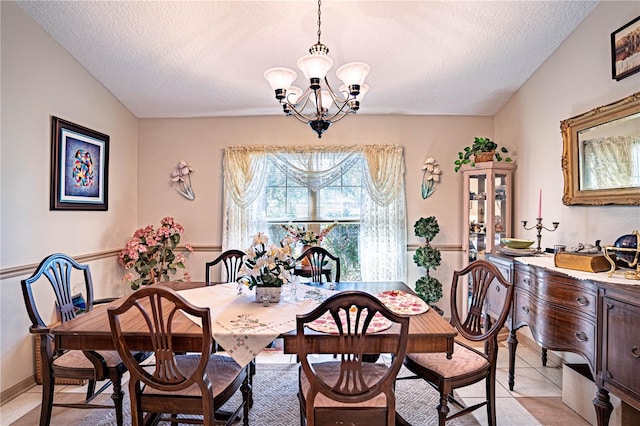 dining area featuring a textured ceiling, light tile patterned floors, lofted ceiling, and an inviting chandelier