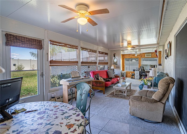 sunroom with a baseboard radiator and a ceiling fan