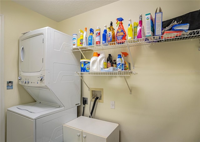 laundry room with stacked washer and dryer, laundry area, and a textured ceiling