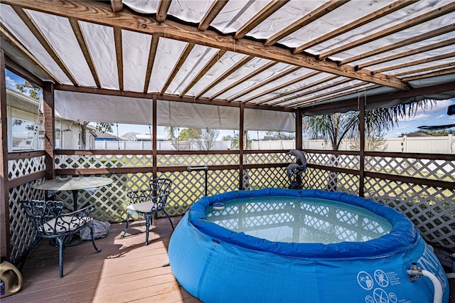 wooden terrace featuring a hot tub and fence