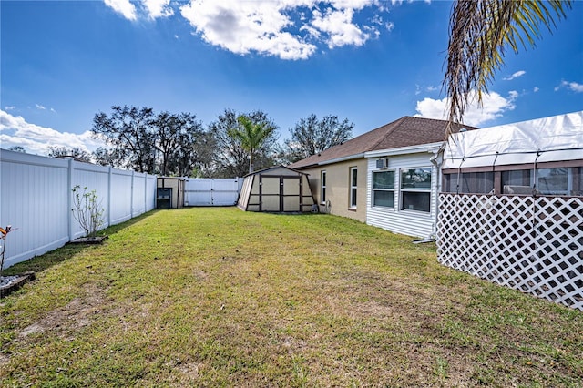 view of yard with a fenced backyard, a storage unit, and an outdoor structure