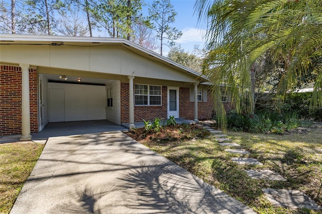 view of front facade featuring driveway and brick siding