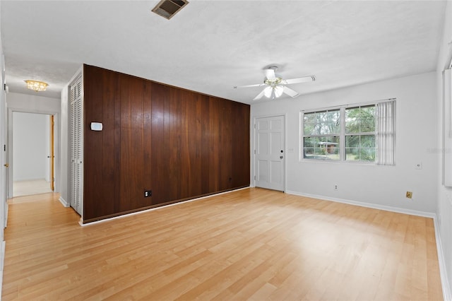 spare room with ceiling fan, light wood-style flooring, visible vents, and baseboards