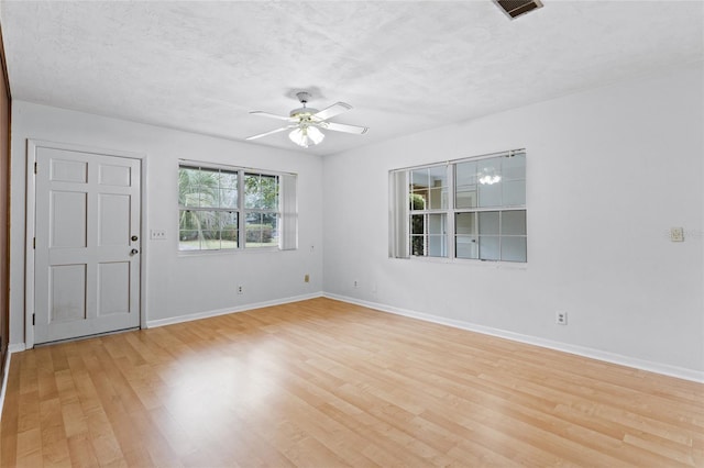 empty room with light wood-style floors, baseboards, and a ceiling fan