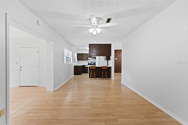 living room with a ceiling fan, light wood-style flooring, and baseboards