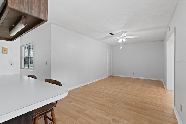 office area featuring light wood-style flooring, visible vents, baseboards, and ceiling fan