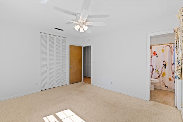 unfurnished bedroom featuring visible vents, baseboards, a closet, carpet, and ensuite bath