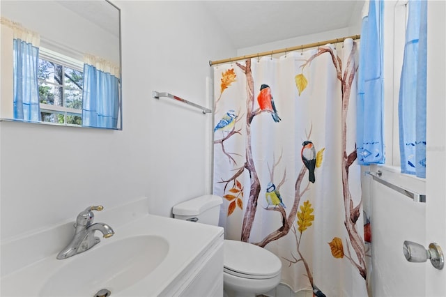 bathroom featuring toilet, a shower with shower curtain, and vanity