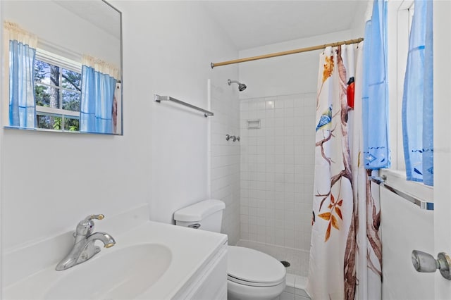 full bathroom with tiled shower, vanity, and toilet