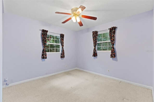 spare room featuring carpet, plenty of natural light, a ceiling fan, and baseboards