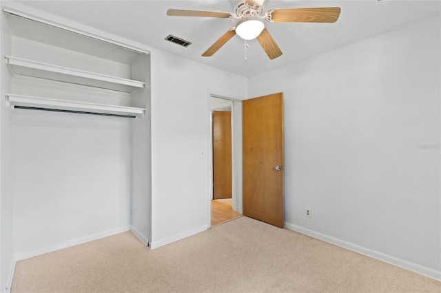 unfurnished bedroom featuring carpet floors, a closet, visible vents, a ceiling fan, and baseboards