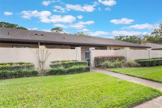 rear view of house featuring a fenced front yard, a gate, and stucco siding