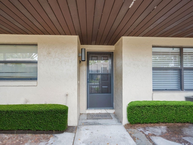 doorway to property featuring stucco siding