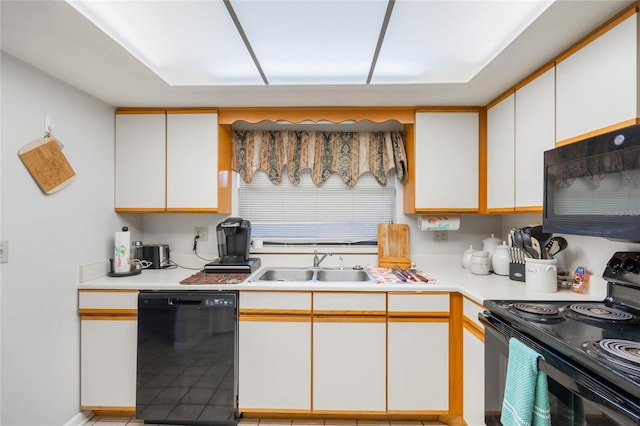 kitchen featuring black appliances, white cabinets, a sink, and light countertops