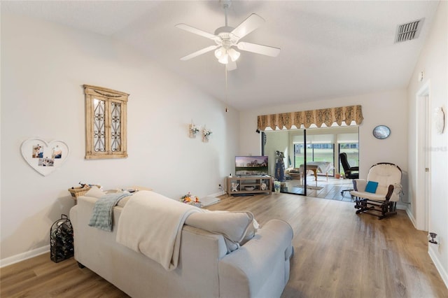 living area with lofted ceiling, visible vents, ceiling fan, wood finished floors, and baseboards