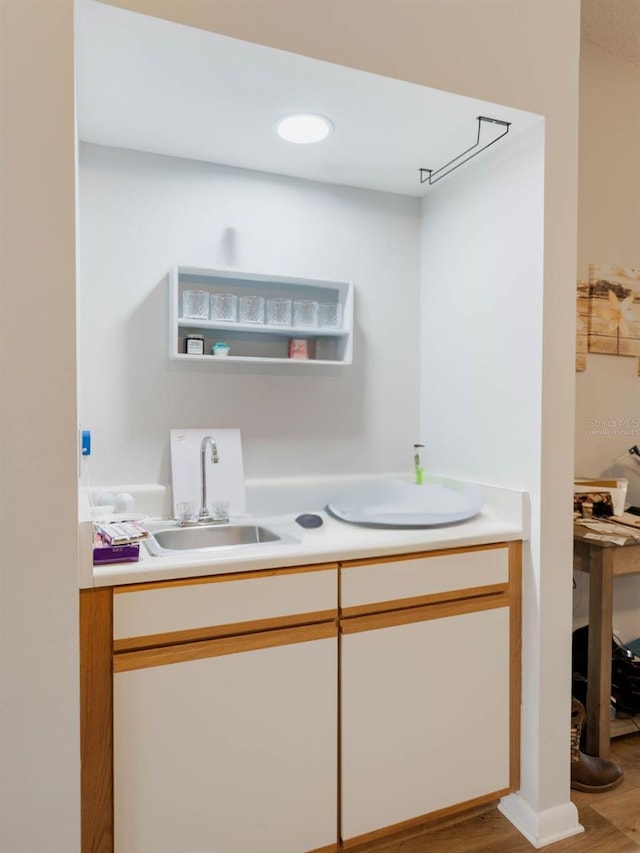 full bath with wood finished floors, a sink, and double vanity