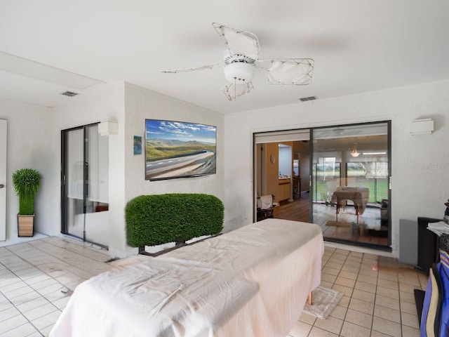 bedroom featuring light tile patterned flooring, a wall unit AC, and visible vents