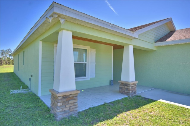 property entrance with covered porch, a yard, and roof with shingles