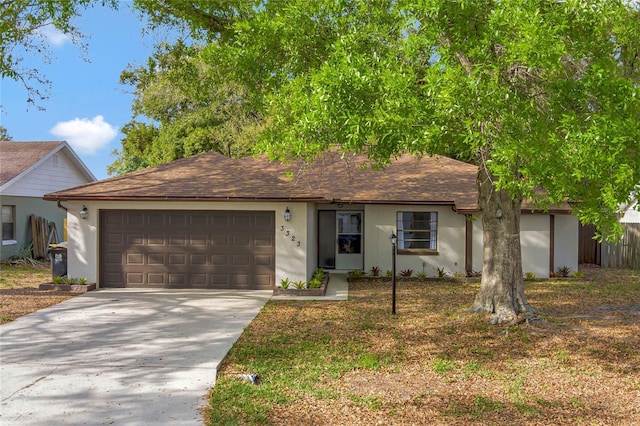 ranch-style home featuring a garage, driveway, fence, and stucco siding