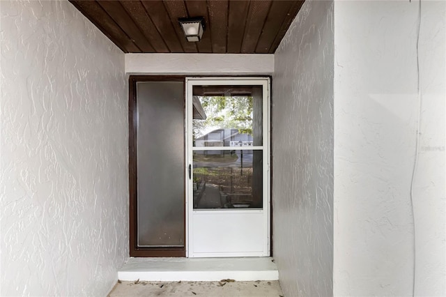 doorway to property featuring stucco siding