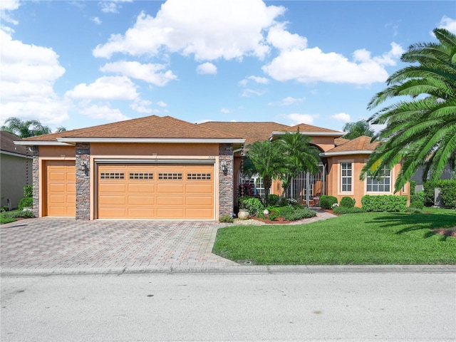 view of front of home featuring decorative driveway, stone siding, and stucco siding