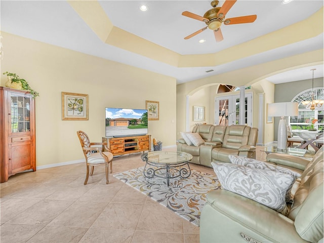 living area with ceiling fan with notable chandelier, baseboards, arched walkways, and recessed lighting