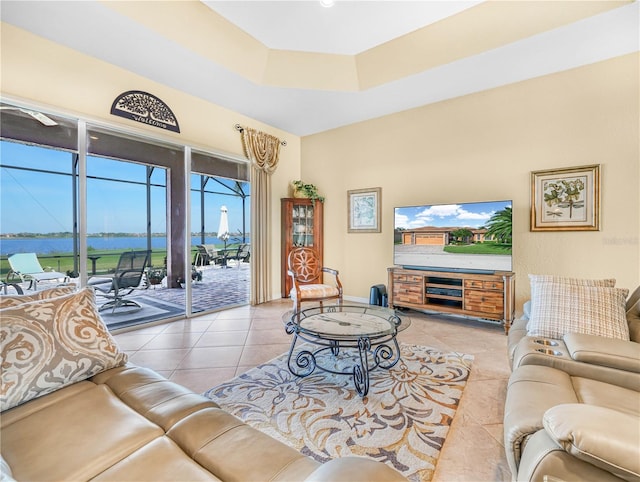 tiled living room featuring a tray ceiling and baseboards