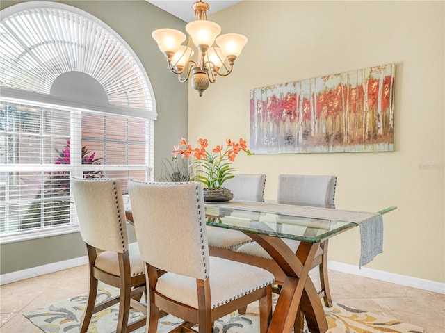 dining area featuring a chandelier, baseboards, and tile patterned floors