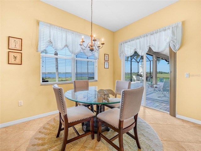 dining space featuring a healthy amount of sunlight, a notable chandelier, baseboards, and light tile patterned flooring