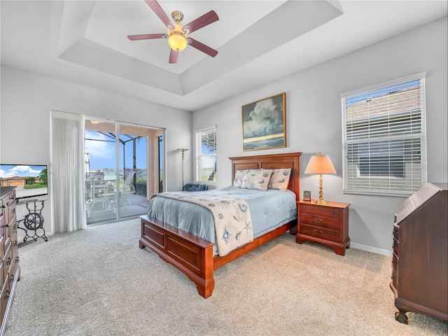 bedroom featuring baseboards, carpet floors, a tray ceiling, and access to exterior