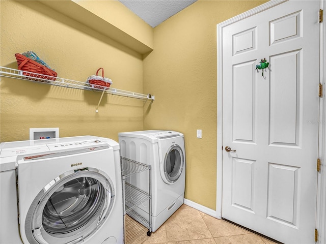 laundry room with washer and dryer, laundry area, baseboards, and light tile patterned floors