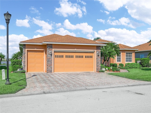 view of front of house featuring stone siding, decorative driveway, a front yard, and stucco siding