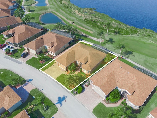 drone / aerial view featuring a residential view, view of golf course, and a water view