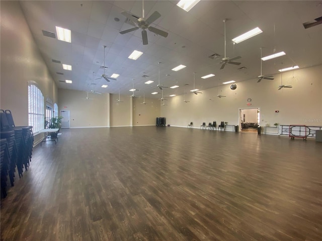 miscellaneous room with ceiling fan, a high ceiling, and wood finished floors