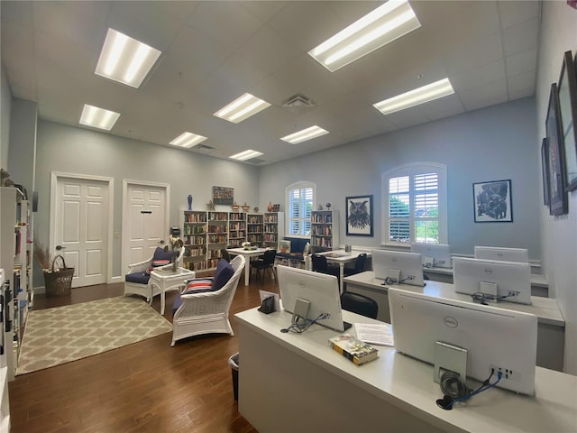 home office with dark wood-style flooring, a drop ceiling, and visible vents